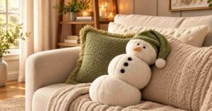 Winter Home Decor Ideas with a cozy sofa, chunky knit blankets, warm candles, and a festive snowman pillow.