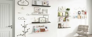 Stylish home decor with floating wall shelves, framed art, books, and cozy seating ideas for a modern living room.