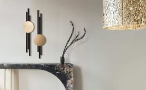 Modern wall decor with black geometric accents, round beige art, marble console table, and pendant lighting.