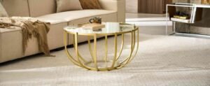 Gold coffee table styled with decor in a modern living room featuring cozy living room items.