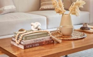 Cozy living room coffee table with books, beads, and ceramic decor.