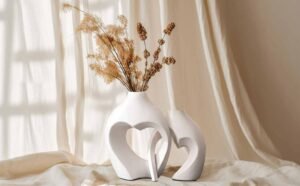 Home Decor Finds Under $50 featuring elegant white vases with dried floral stems in a cozy neutral setting.