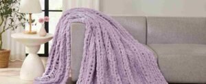 Lavender throw blanket draped over a gray sofa.