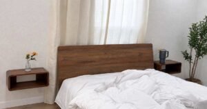 Small bedroom ideas with a space-saving wooden bed and floating nightstands.